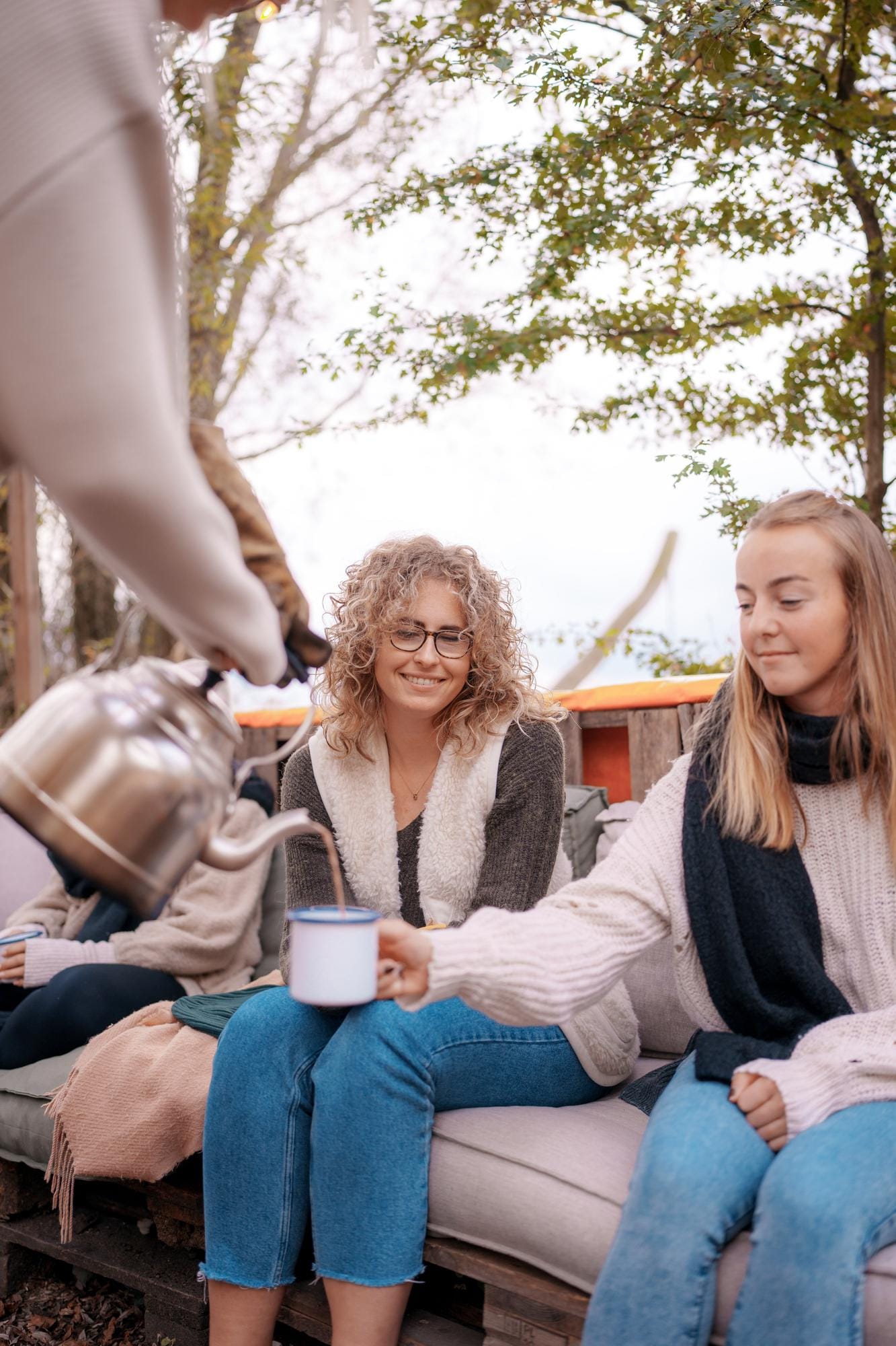 Michelle in relaxte modus met een kop thee, buiten in de natuur.